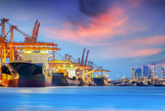 Container Cargo freight ship with working crane bridge in shipyard at dusk for Logistic Import Export background